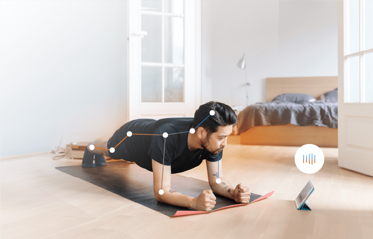 A man doing a plank on the floor, while looking at a tablet. Connecting lines are overlayed on his body aligning with joints and skeleton.