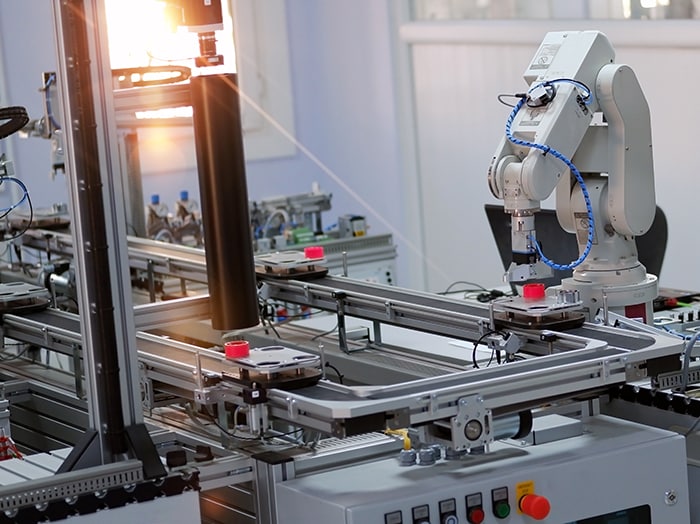 Industrial robots operate behind safety barriers.