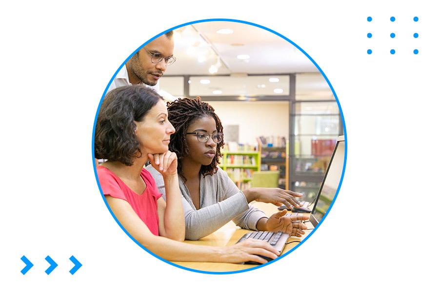 Students and teacher in a lab looking at a computer monitor