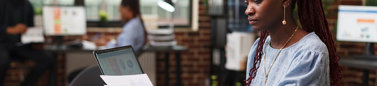 一位女性坐在辦公室的桌前，正在查看文件。